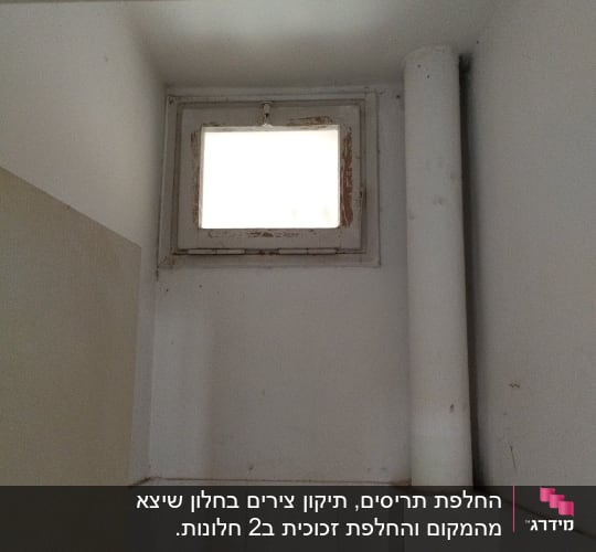 חלון קטן עם תריסים ישנים ומסגרת מתקלפת